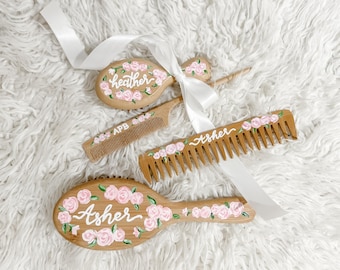 May include: Three wooden hair brushes with pink floral designs and personalised names: "Heather", "Asher", and "Asher".