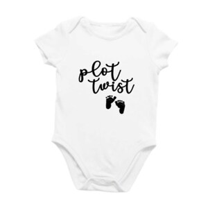 May include: White baby grow with black text that reads "plot twist" and two black footprints below the text.