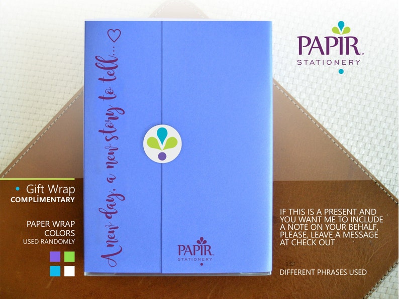 Op de afbeelding: Een blauwe kaart met de tekst "A new day, a new story to tell..." en het logo "PAPIR STATIONERY". De kaart is verpakt in gratis cadeaupapier met een keuze aan kleuren.
