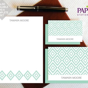 Op de afbeelding: Een set briefpapier met een geometrisch patroon in tinten groen en wit. Het briefpapier bevat een notitieblok met de naam "TAMARA MOORE" bovenaan en een set kaartjes met hetzelfde patroon en dezelfde naam.