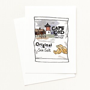 May include: A white greeting card featuring an illustration of a Cape Cod potato chip bag. The bag design includes a lighthouse, the words "Cape Cod" and "Original Sea Salt." Two chips are shown in the lower right corner.