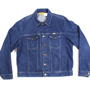 May include: A blue denim jacket with a button closure and two chest pockets.