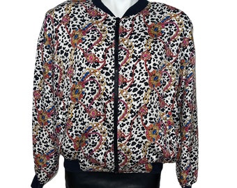 May include: A white bomber jacket with a black zipper and a leopard print pattern with gold chains and colorful jewels.