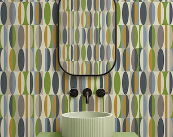 May include: A round, light green ribbed basin sits on a matching green tiled vanity. Above, a rectangular mirror with a black frame reflects a wall covered in wallpaper featuring a repeating pattern of vertical ovals in olive, blue, and gray.