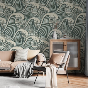 May include: A room featuring a wallpaper with a repeating wave pattern in shades of teal and cream. A tan leather sofa, a gray chair, and a wooden cabinet with glass doors are in the room. A gray blanket and pillows are on the furniture.