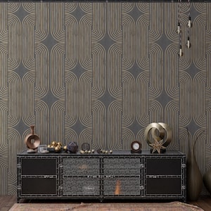 Pode incluir: Uma parede cinza escuro com um padrão art déco dourado repetido. Um armário de metal preto com portas de malha contém itens decorativos, incluindo um relógio, esferas douradas e vasos. Um tapete é visível no chão.