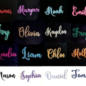 Op de afbeelding: Een verzameling van 16 namen bedekt met glitter, waaronder James, Harper, Noah, Emily, Ivy, Olivia, Kayden, Freya, Amelia, Liam, Chloe, Holly, Mason, Sophia, Daniel en Tommy. De namen zijn gerangschikt in vier rijen van vier, met elke naam op een aparte zwarte of witte achtergrond.