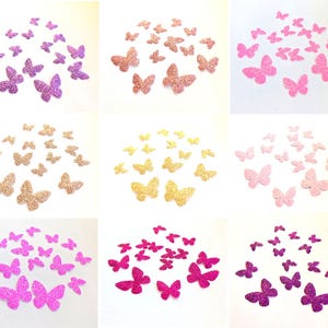 Op de afbeelding: Een verzameling glittervlinderversieringen in verschillende kleuren, waaronder roze, goud en paars. De vlinders zijn gerangschikt in kleine clusters, ideaal voor knutselen en decoraties. De glitter voegt een sprankelend effect toe aan de vlindervormen.