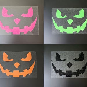 Könnte beinhalten: Vier Halloween-Gesichtsdesigns mit Glitzer. Die Designs umfassen ein pinkfarbenes, grünes, orangefarbenes und schwarzes Kürbisgesicht. Jedes Gesicht befindet sich auf einem transparenten Hintergrund, ideal für Bastelprojekte.