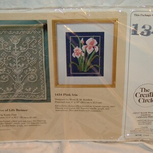 May include: A close-up of two embroidery kits, one featuring a pink iris and the other a tree of life design. The kits are packaged together and include the text "The Creative Circle" and "ACOC 1344".