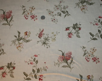 Puede incluir: Una tela azul claro con un delicado estampado floral con pequeñas flores rosas, blancas y amarillas. La tela tiene una textura sutil y una sensación ligera y aireada.