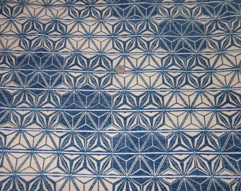 Puede incluir: Tela con estampado geométrico azul y blanco con un brillo sutil. El patrón presenta un diseño repetitivo de estrellas y diamantes.