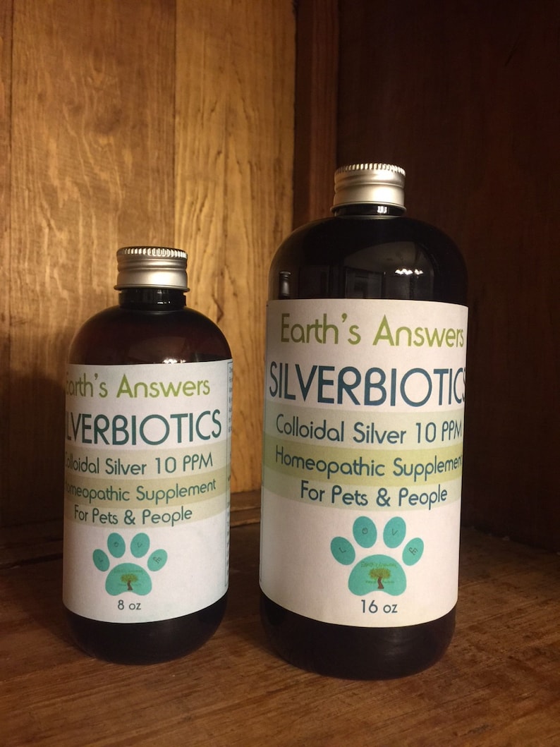May include: Two brown glass bottles with silver lids. The bottles are labeled "Earth's Answers" and "Silverbiotics". The smaller bottle is 8 ounces and the larger bottle is 16 ounces. Both bottles contain colloidal silver 10 ppm homeopathic supplement for pets and people.