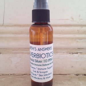 May include: A brown glass bottle with a black spray top and a white label that reads "EARTH'S ANSWERS SILVERBIOTICS Colloidal Silver 10 PPM Homeopathic Immune Defense for Pets Germs * Immune Support Cuts & Scrapes Hot Spots * Skin Infections Eye Infections & More"