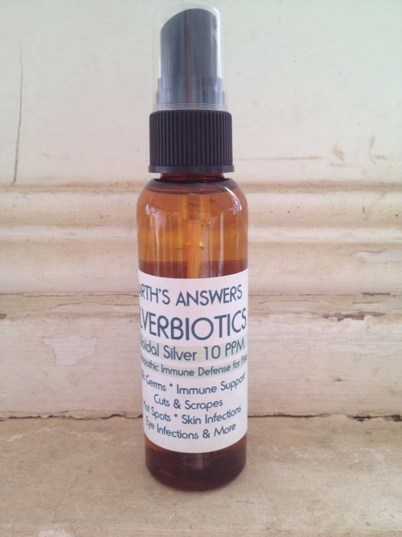 May include: A brown glass bottle with a black spray top and a white label that reads "EARTH'S ANSWERS SILVERBIOTICS Colloidal Silver 10 PPM Homeopathic Immune Defense for Pets Germs * Immune Support Cuts & Scrapes Hot Spots * Skin Infections Eye Infections & More"