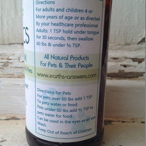 May include: A brown glass bottle with a white label. The label has the text "Directions" and instructions for using the product for adults, children, and pets. The label also includes the website "www.earths-answers.com".