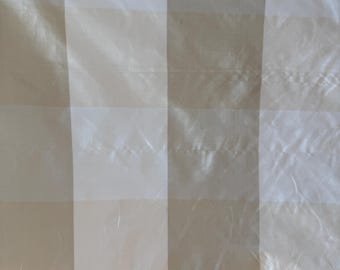 May include: Close-up of a fabric with a striped pattern. The fabric has alternating vertical stripes of off-white and a light beige color. The material appears to be slightly shiny and has a subtle texture.
