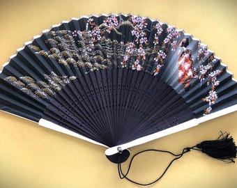 Abanico de mano vintage. Abanico japonés negro con diseño de flor de cerezo.