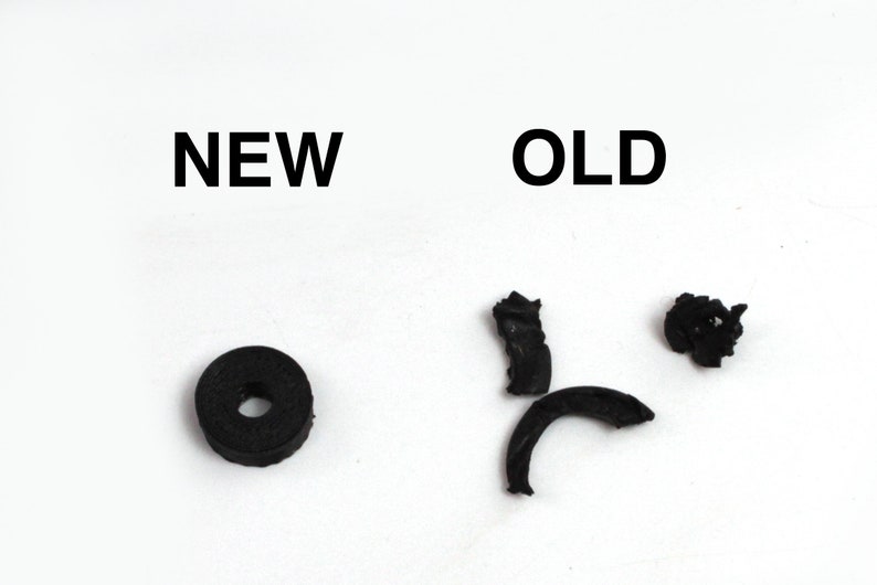 May include: A comparison of a new and old rubber washer. The new washer is a solid black ring. The old washer is broken into three pieces.