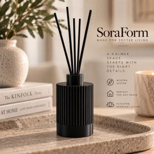 May include: A black reed diffuser with a cylindrical, vertically ribbed base and five thin black reeds. The text SoraForm MADE FOR SOFTER LIVING. A CALMER SPACE STARTS WITH THE RIGHT DETAILS. MODERN DESIGN, PERFECT FOR ANY SPACE, ELEVATED EVERYDAY LIVING.