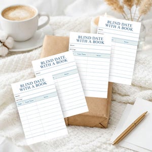 Könnte beinhalten: Weiße Papierblätter mit dem Text "BLIND DATE WITH A BOOK" sind auf einer weichen, weißen Oberfläche angeordnet. Die Blätter haben Linien für Notizen und einen Abschnitt für eine Bewertung. Eine Tasse Kaffee und ein Geschenk sind im Hintergrund.