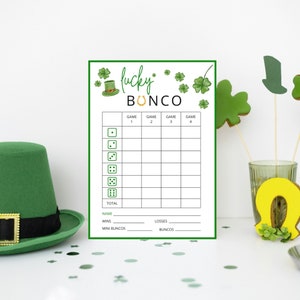 May include: A printable St. Patrick's Day themed Lucky Bunco scorecard with a green leprechaun hat and gold horseshoe graphic. The scorecard has columns for four games, a total score, and spaces for name, wins, losses, mini buncos, and buncos.