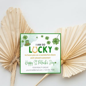 May include: A green watercolor card with shamrocks and a leprechaun hat. The card says "I am so lucky to have you as a wonderful client and valued customer! Happy St. Patrick's Day." It also includes the text "YOUR REALTY GROUP, youremall@email.com | 123-456-7890".