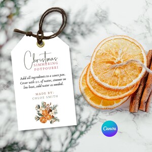 May include: A white gift tag with a handwritten title "Christmas Simmering Potpourri". The tag includes instructions for making potpourri and a handwritten note "Made By: Chloe Smith". The tag is decorated with a watercolor illustration of oranges, cinnamon sticks, and evergreen sprigs.