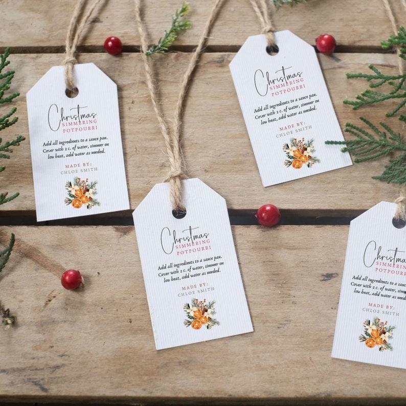 May include: Four white gift tags with a rustic twine string. Each tag features a Christmas-themed design with a floral illustration and the text "Christmas Simmering Potpourri". The text includes instructions for using the potpourri, along with the words "Made By: Chloe Smith".
