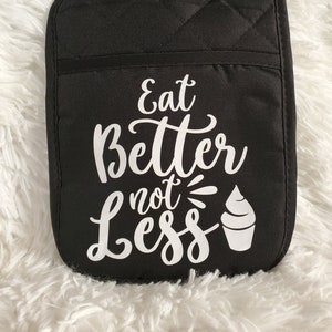 May include: Black oven mitt with white text that reads "Eat Better not Less" and a white ice cream cone graphic.