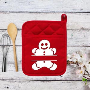 May include: Red quilted oven mitt with a white gingerbread man design. The gingerbread man has a smiling face and a split line for personalization.
