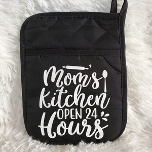 May include: Black quilted oven mitt with white text that reads "Mom's Kitchen Open 24 Hours".