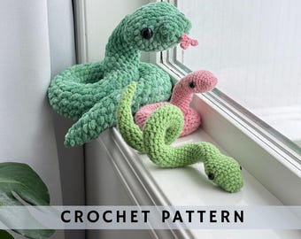 May include: Three crocheted snakes, one green, one pink, and one green with a lighter green head, are arranged on a windowsill. The text "CROCHET PATTERN" is visible at the bottom of the image.