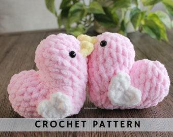 May include: Two pink crocheted birds with white hearts and yellow beaks. The birds are facing each other and appear to be kissing. The text "CROCHET PATTERN" is at the bottom of the image.