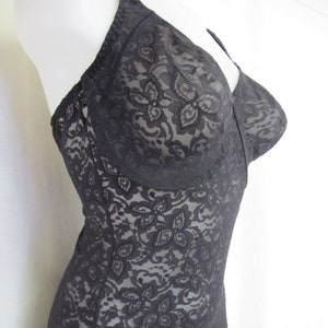 May include: Black lace bodysuit with a floral pattern. The bodysuit has a low neckline and adjustable straps.
