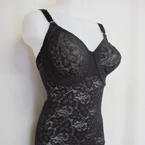 May include: Black lace body suit with adjustable straps. The suit has a floral pattern and is made of a sheer fabric.
