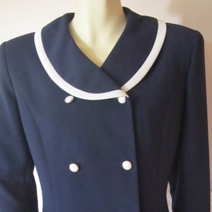May include: A navy blue blazer with a white collar and six white buttons.