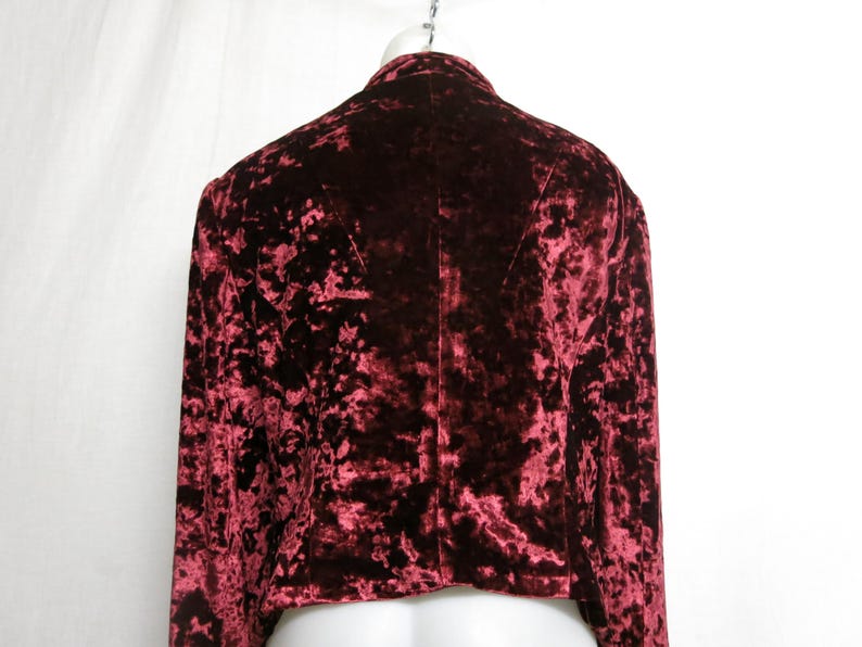 May include: A red crushed velvet jacket with long sleeves. The jacket has a cropped length and a classic collar.