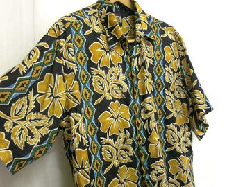 Camicia hawaiana di seta con stampa floreale geometrica audace, nera e oro, stile campeggio, vintage tropicale.