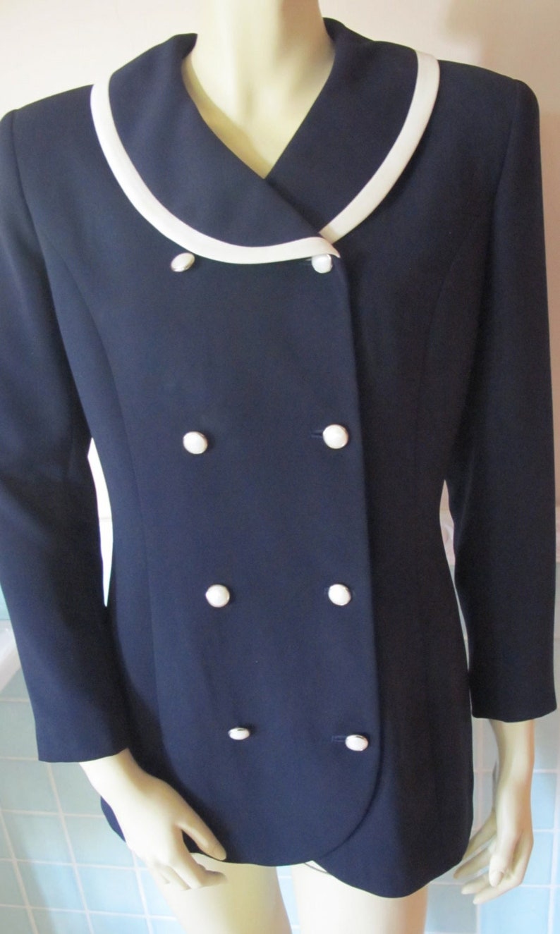 May include: A navy blue blazer with a white collar and six white buttons.