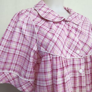 May include: A pink and white plaid short-sleeved nightgown with white trim and buttons.