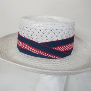 Puede incluir: Un sombrero de paja blanco con una cinta de list&oacute;n a cuadros azul y rojo.