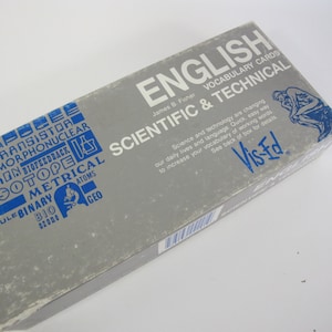 Peut inclure: Une boîte rectangulaire de cartes de vocabulaire anglais pour les termes scientifiques et techniques. La boîte est grise avec du texte bleu et blanc, avec les mots "English", "Scientific & Technical" et "Vis-Ed."