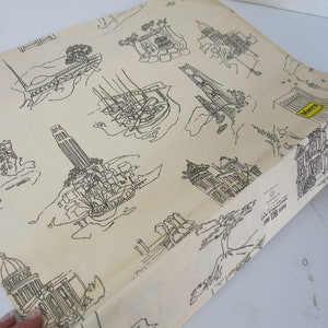 May include: A cream-colored wrapping paper with a black and white repeating pattern of San Francisco landmarks, including the Golden Gate Bridge, Coit Tower, and the Palace of Fine Arts. The paper has the word "Marty's" printed in yellow on one of the buildings.