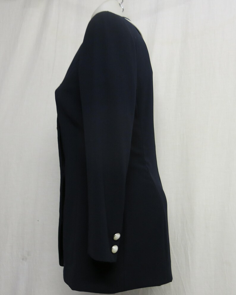 May include: A navy blue blazer with long sleeves and two white buttons on each cuff.