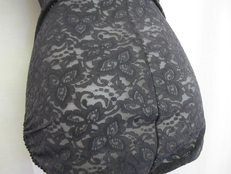 May include: Black lace bodysuit with a floral pattern.