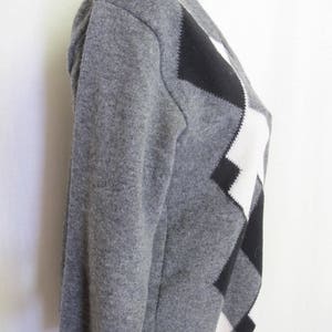 May include: A gray sweater with a black and white diamond pattern.