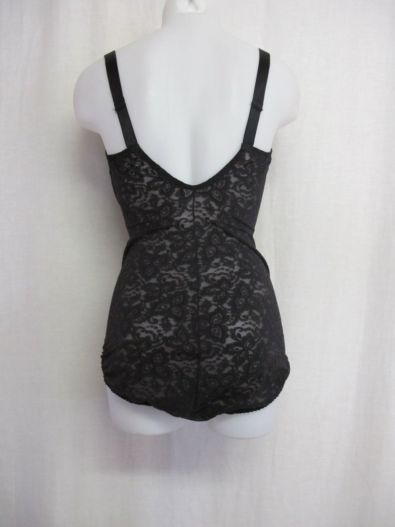 May include: Black lace body suit with adjustable straps. The suit has a low back and a smooth, seamless finish.