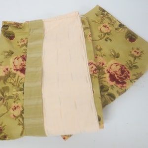 May include: Three pieces of fabric with a floral pattern. The fabric is green with pink and red roses. One piece of fabric has a striped pattern in green and white.