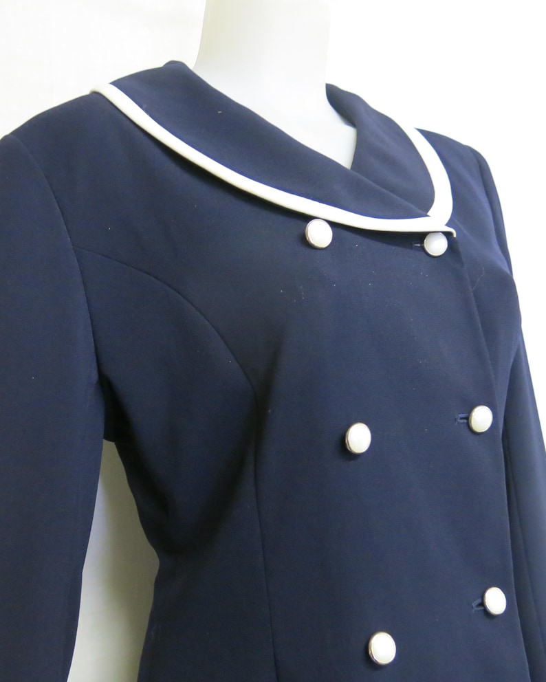May include: A navy blue blazer with a white collar and white buttons. The blazer has a double-breasted closure.
